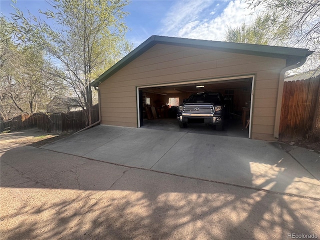 garage with fence and driveway