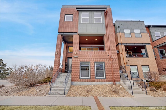 view of property featuring brick siding and a balcony