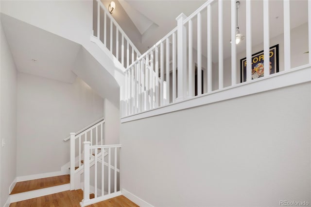 stairs with wood finished floors and baseboards