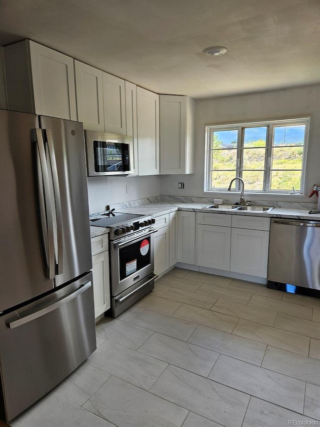 kitchen featuring sink, white cabinets, and appliances with stainless steel finishes