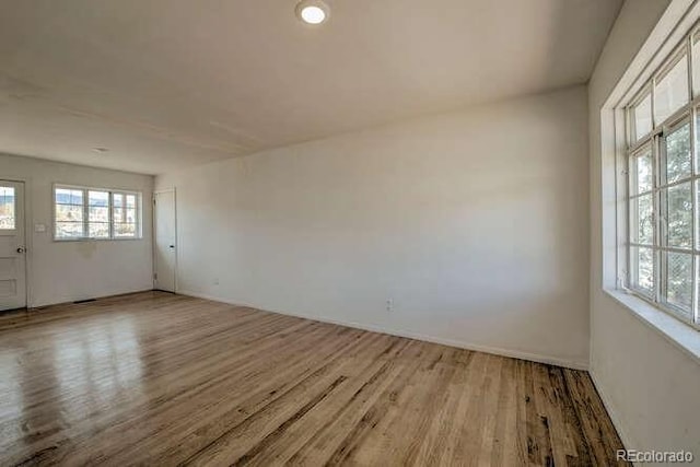 unfurnished room featuring hardwood / wood-style floors and plenty of natural light