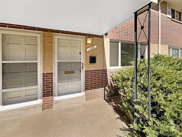 doorway to property with brick siding