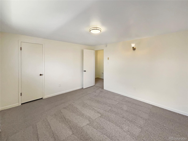 carpeted empty room with baseboards