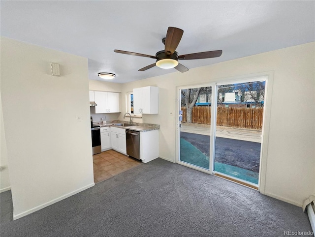 kitchen with light carpet, a sink, appliances with stainless steel finishes, white cabinets, and ceiling fan