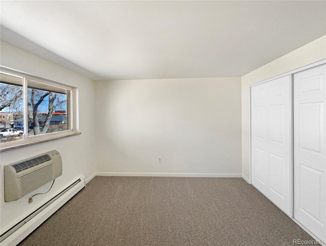 unfurnished bedroom with a baseboard heating unit, carpet floors, baseboards, and a closet