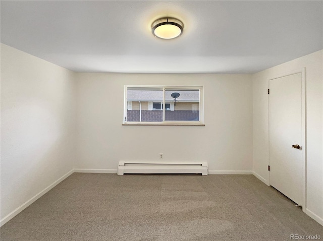 empty room with baseboards, baseboard heating, and carpet