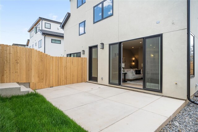 2520 S Cherokee St, Denver, CO 80223 - back of property with stucco siding, fence, and a patio