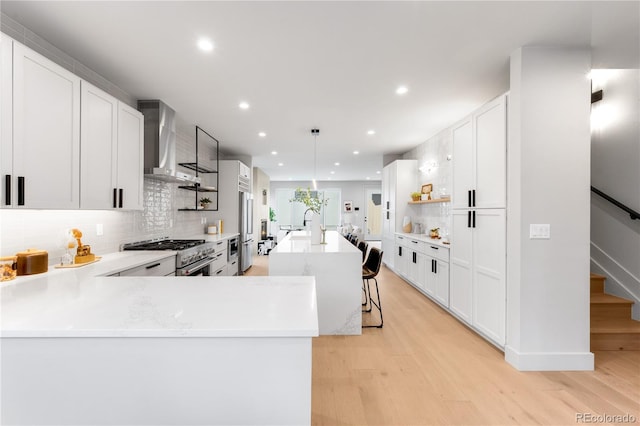2520 S Cherokee St, Denver, CO 80223 - kitchen with backsplash, wall chimney range hood, recessed lighting, and high end appliances