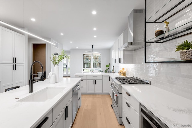 2520 S Cherokee St, Denver, CO 80223 - kitchen with a sink, wall chimney exhaust hood, appliances with stainless steel finishes, tasteful backsplash, and recessed lighting