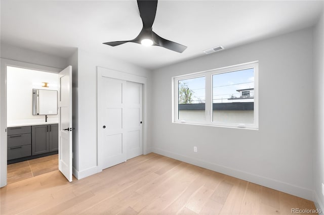 2520 S Cherokee St, Denver, CO 80223 - unfurnished bedroom with a closet, light wood-style floors, visible vents, and baseboards