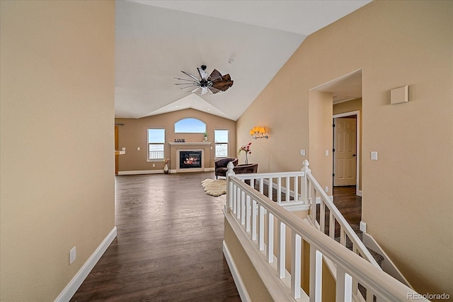 hallway with dark wood-type flooring and vaulted ceiling