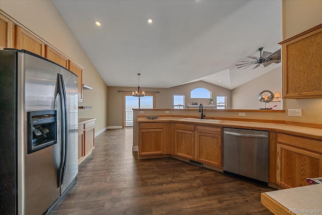 kitchen with sink, decorative light fixtures, vaulted ceiling, dark hardwood / wood-style floors, and stainless steel appliances