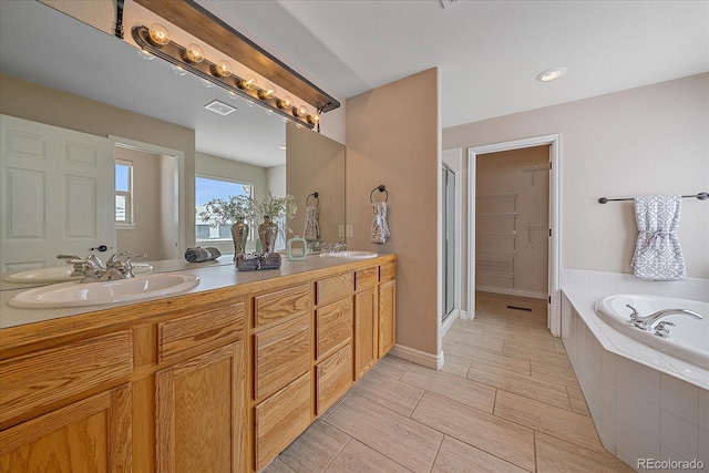 bathroom featuring vanity and independent shower and bath