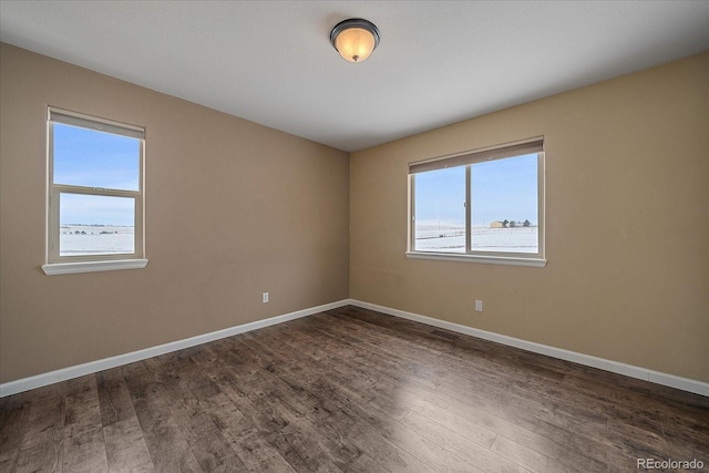 empty room with dark hardwood / wood-style flooring