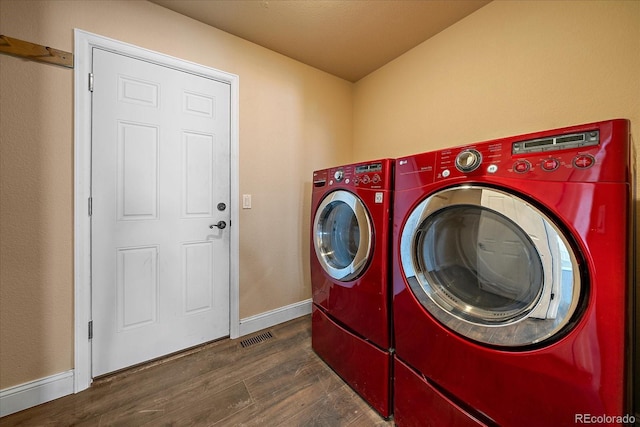 clothes washing area featuring washing machine and dryer and dark hardwood / wood-style floors