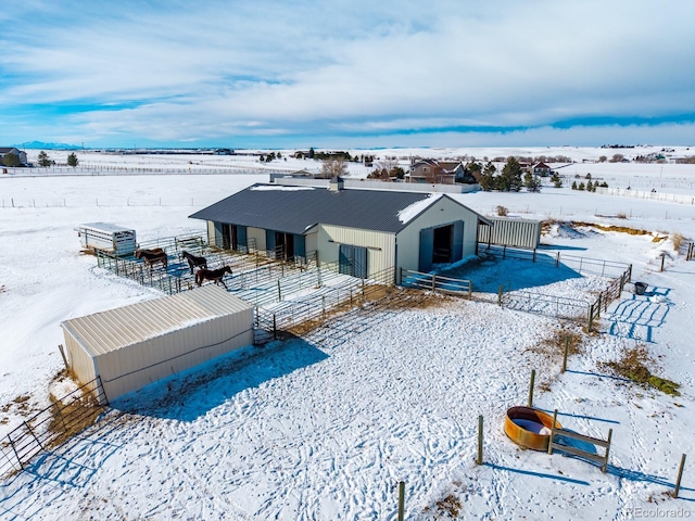 snow covered rear of property with an outdoor structure