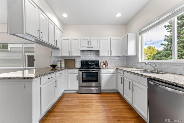 kitchen with appliances with stainless steel finishes, light hardwood / wood-style floors, white cabinetry, and sink