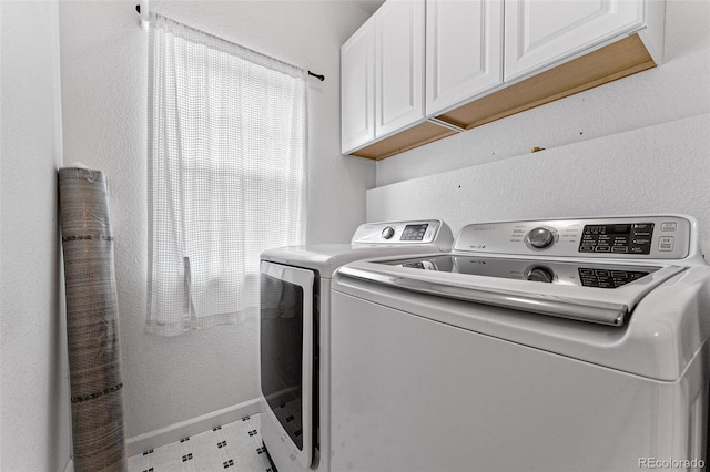 laundry room featuring light tile patterned floors, washer and dryer, and cabinets