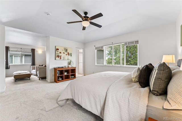 bedroom with ceiling fan, a raised ceiling, lofted ceiling, and carpet flooring