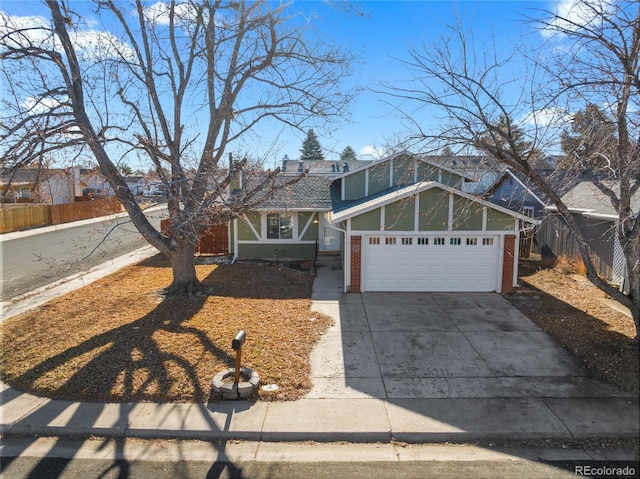 view of front of house featuring a garage, fence, concrete driveway, and brick siding