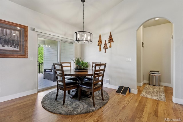3125 Brunner Blvd, Johnstown, CO 80534 - dining area featuring arched walkways, wood finished floors, and a chandelier