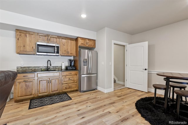 3125 Brunner Blvd, Johnstown, CO 80534 - kitchen with stainless steel appliances, dark countertops, and light wood-style floors