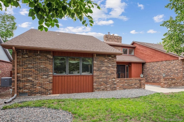 11254 E Colorado Dr, Aurora, CO 80012 - rear view of property with a chimney, brick siding, a shingled roof, and a yard