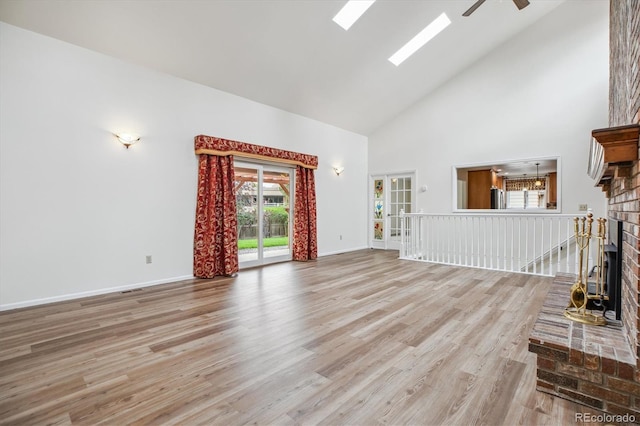 11254 E Colorado Dr, Aurora, CO 80012 - unfurnished living room with high vaulted ceiling, a ceiling fan, plenty of natural light, a brick fireplace, and wood finished floors