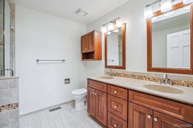 11254 E Colorado Dr, Aurora, CO 80012 - bathroom featuring double vanity, a tile shower, and backsplash