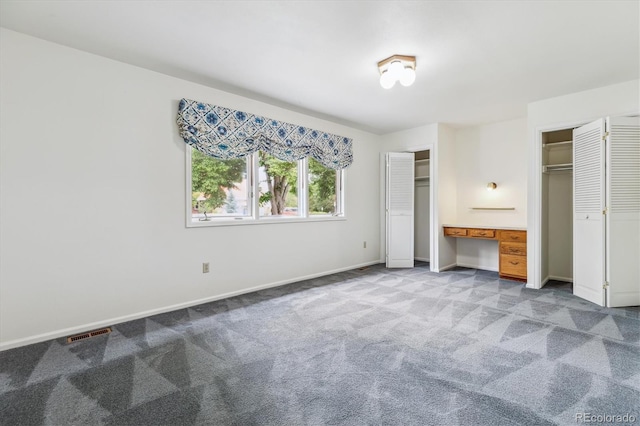 11254 E Colorado Dr, Aurora, CO 80012 - unfurnished bedroom with two closets, carpet floors, and built in desk