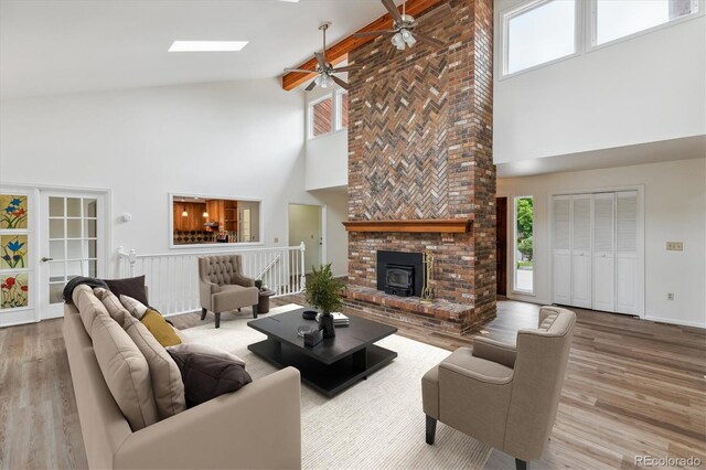11254 E Colorado Dr, Aurora, CO 80012 - living area featuring high vaulted ceiling, wood finished floors, ceiling fan, a skylight, and beamed ceiling