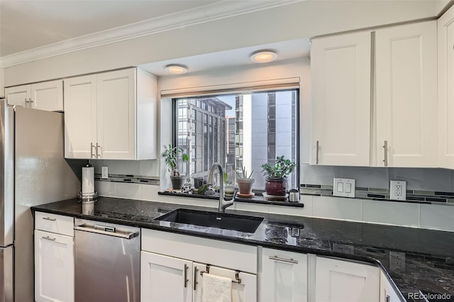 kitchen featuring white cabinetry, sink, dark stone countertops, stainless steel appliances, and crown molding