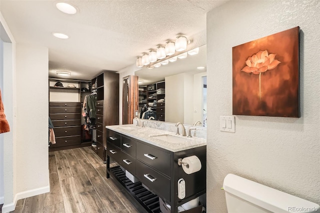 bathroom featuring vanity, toilet, hardwood / wood-style floors, and a textured ceiling