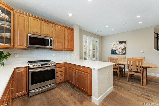 10618 Clearview Ln, Highlands Ranch, CO 80126 - kitchen with stainless steel appliances, dark wood-type flooring, recessed lighting, a peninsula, and backsplash