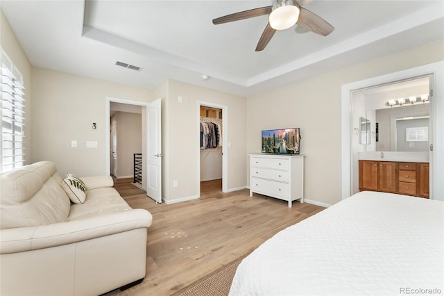 10618 Clearview Ln, Highlands Ranch, CO 80126 - bedroom with light wood-style floors, a walk in closet, ensuite bathroom, a tray ceiling, and a closet