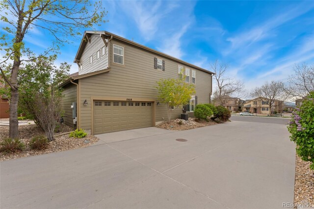 10618 Clearview Ln, Highlands Ranch, CO 80126 - view of side of home with an attached garage, concrete driveway, and central air condition unit
