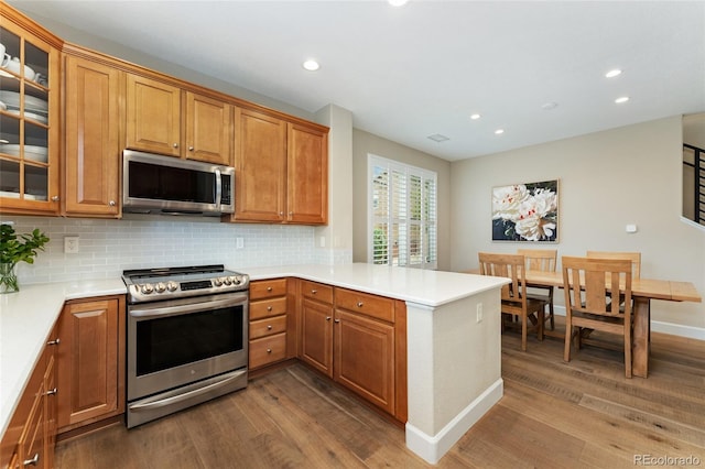10618 Clearview Ln, Highlands Ranch, CO 80126 - kitchen featuring appliances with stainless steel finishes, dark wood-style flooring, recessed lighting, a peninsula, and backsplash