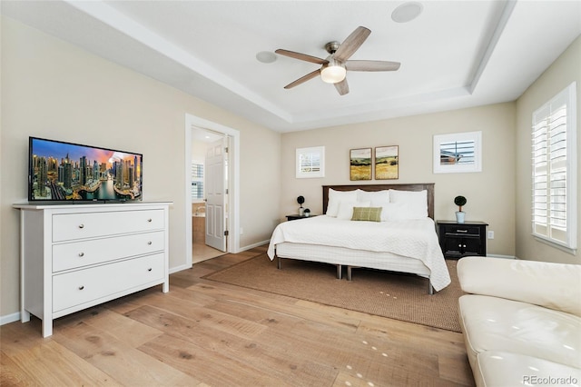 10618 Clearview Ln, Highlands Ranch, CO 80126 - bedroom featuring a raised ceiling, light wood-style floors, ensuite bathroom, and a ceiling fan