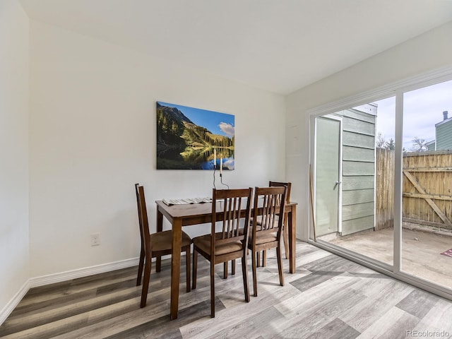 dining space featuring baseboards and wood finished floors
