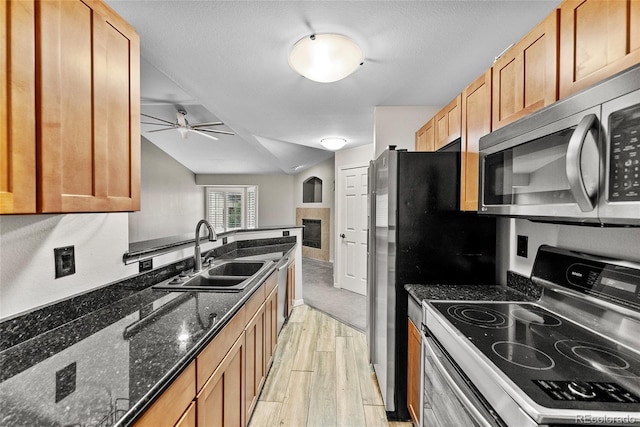 kitchen with dark stone counters, ceiling fan, sink, range with electric stovetop, and light hardwood / wood-style floors