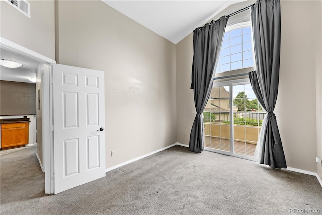 spare room featuring high vaulted ceiling and carpet flooring