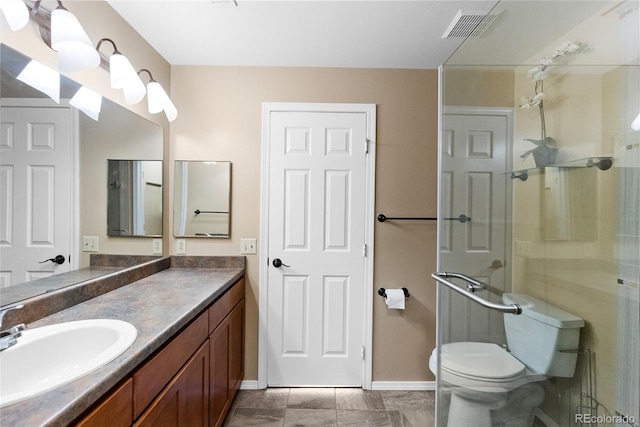 bathroom featuring vanity, a shower with shower door, toilet, and tile patterned flooring