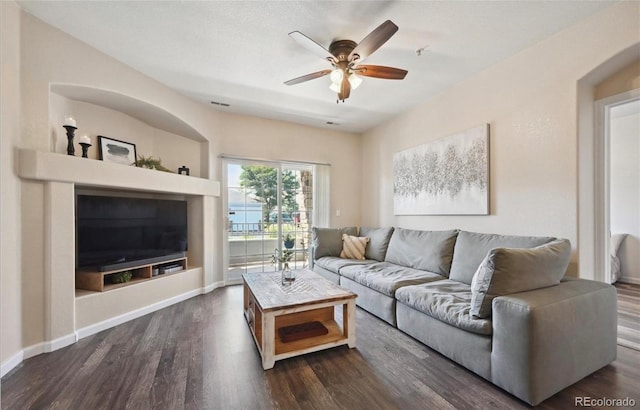 living room featuring ceiling fan and dark hardwood / wood-style flooring