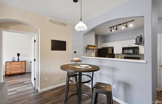 kitchen featuring white cabinetry, dark hardwood / wood-style floors, kitchen peninsula, decorative light fixtures, and black appliances