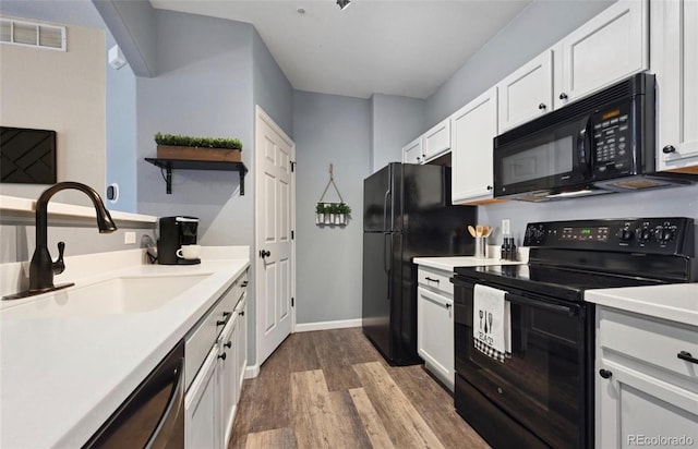 kitchen featuring black appliances, white cabinets, sink, and hardwood / wood-style floors