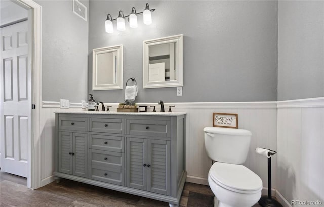 bathroom with hardwood / wood-style flooring, vanity, and toilet