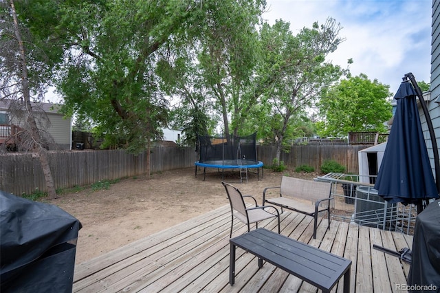 10050 Holland Ct, Broomfield, CO 80021 - wooden deck with a trampoline, a fenced backyard, and a grill