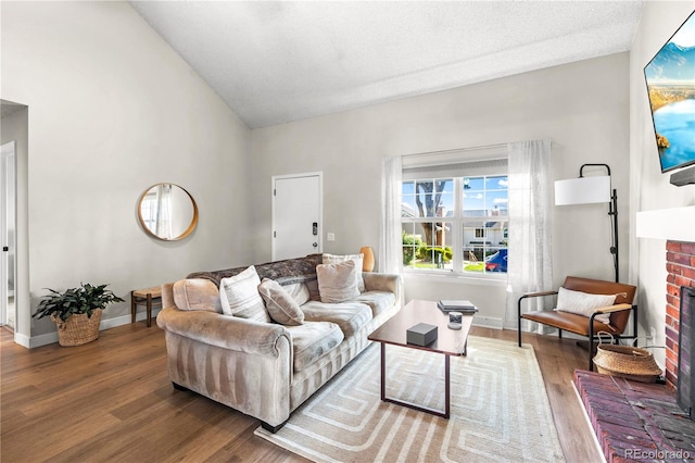 living room featuring baseboards, a brick fireplace, and wood finished floors