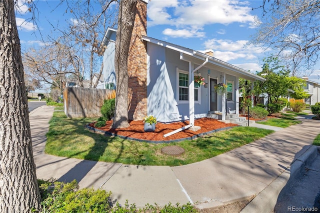 view of front of home with fence and a chimney
