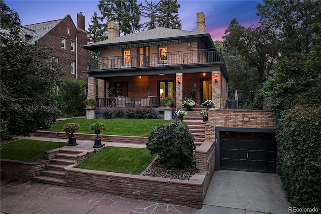 view of front facade with covered porch, a front yard, a balcony, a garage, and driveway